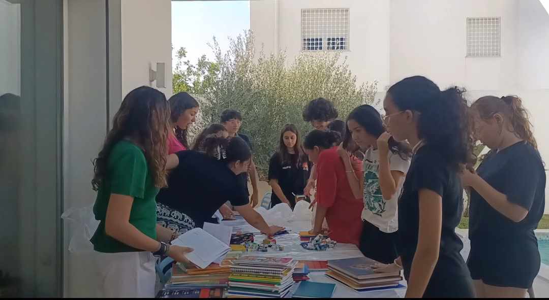 People arranging papers and supplies on a table.