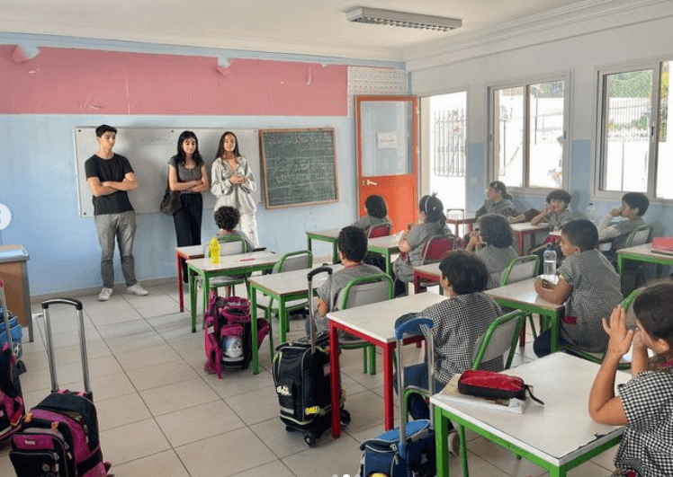 People presenting to a classroom of seated students.