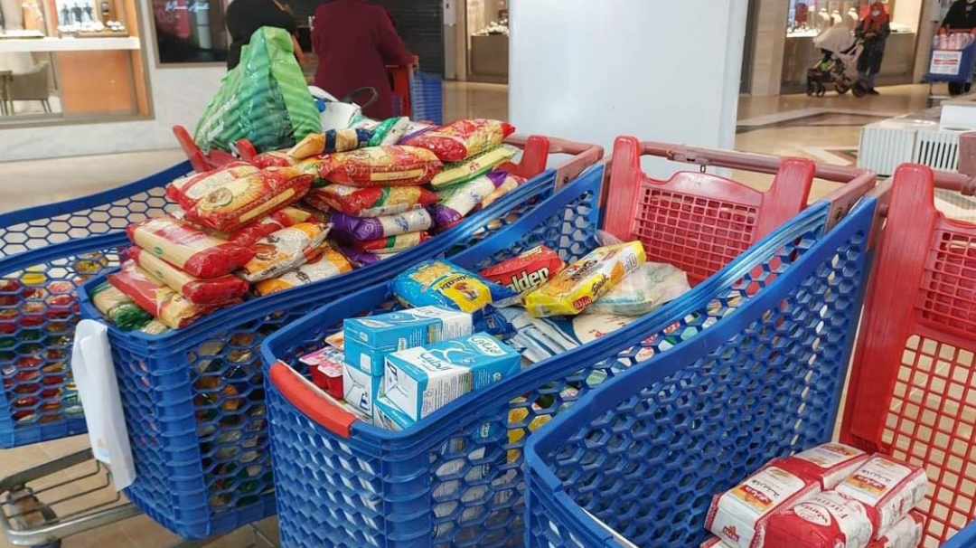 Shopping carts filled with packaged food and drinks.