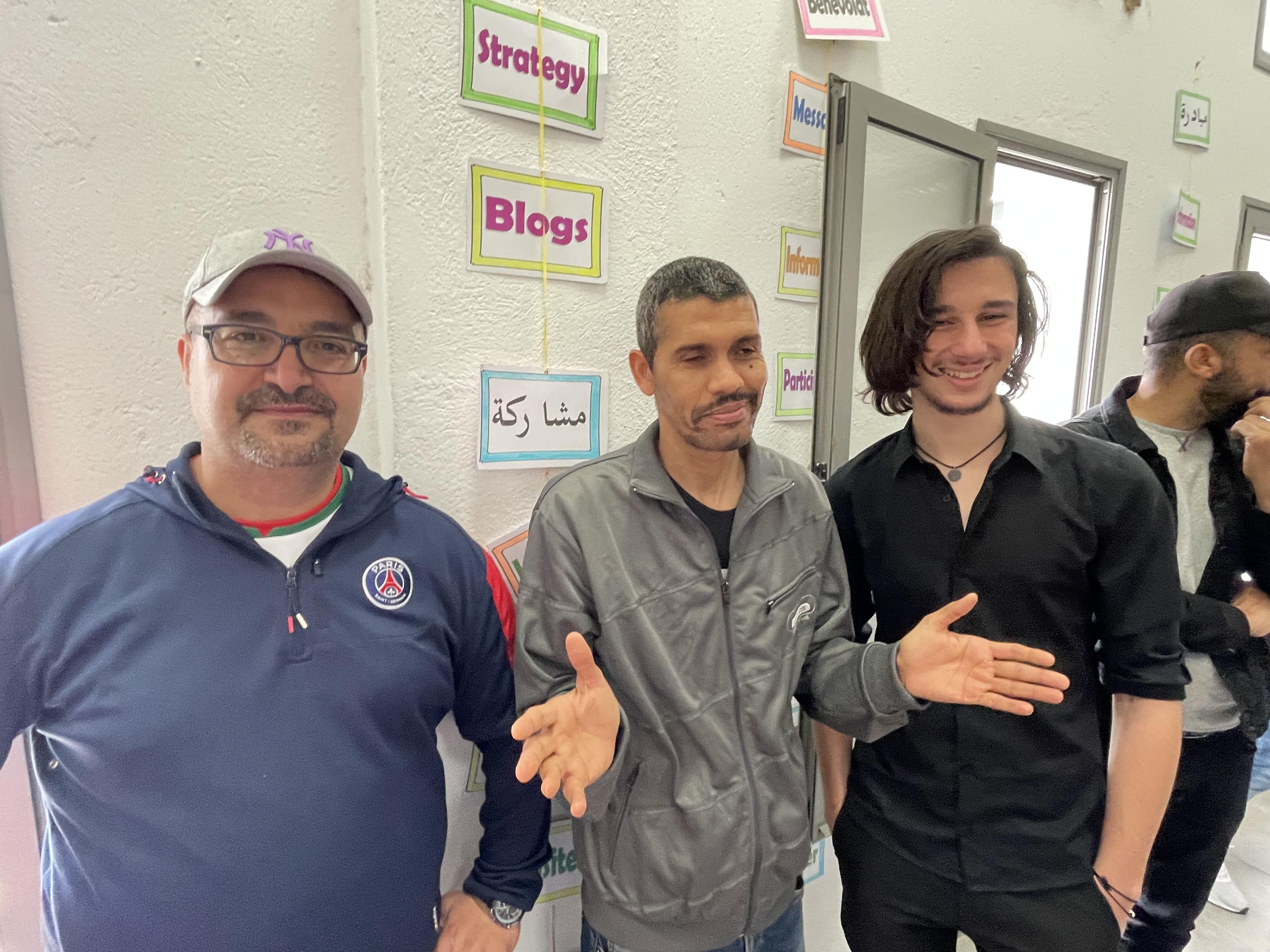 Three people posing together in a room.