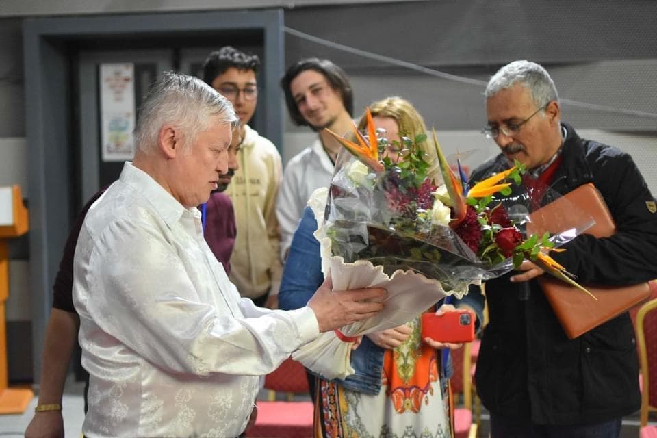 A bouquet being presented during a group gathering.