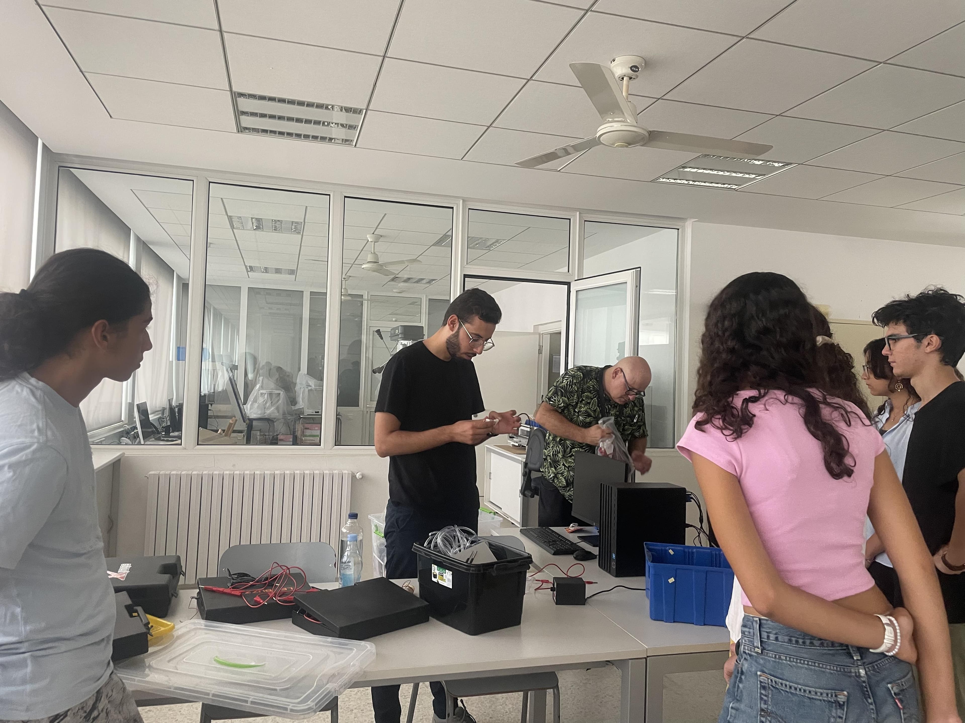People working around equipment on a table.