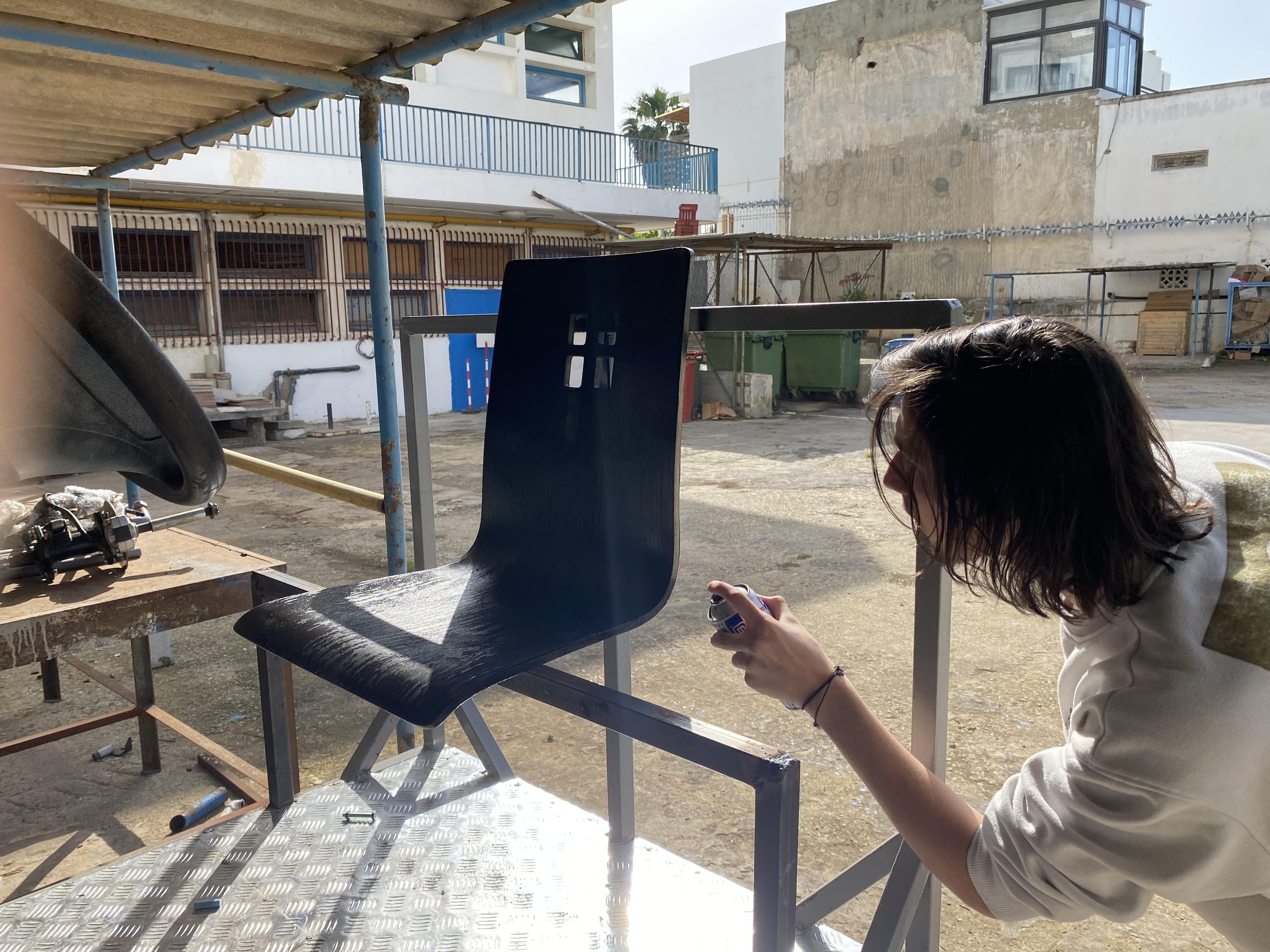 A person working on a blue panel attached to a metal frame.
