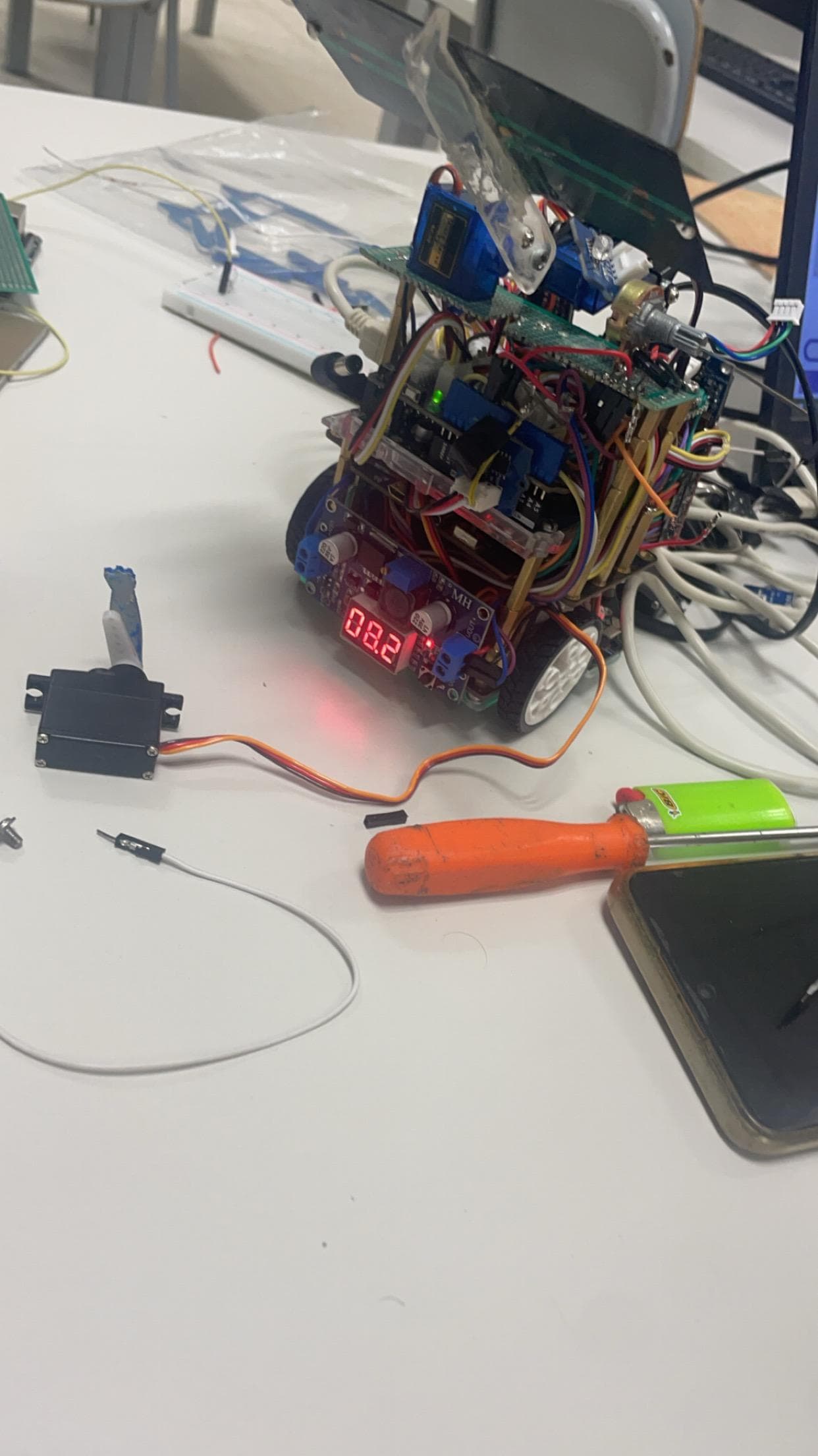 An electronic assembly with exposed wiring and small components on a table.
