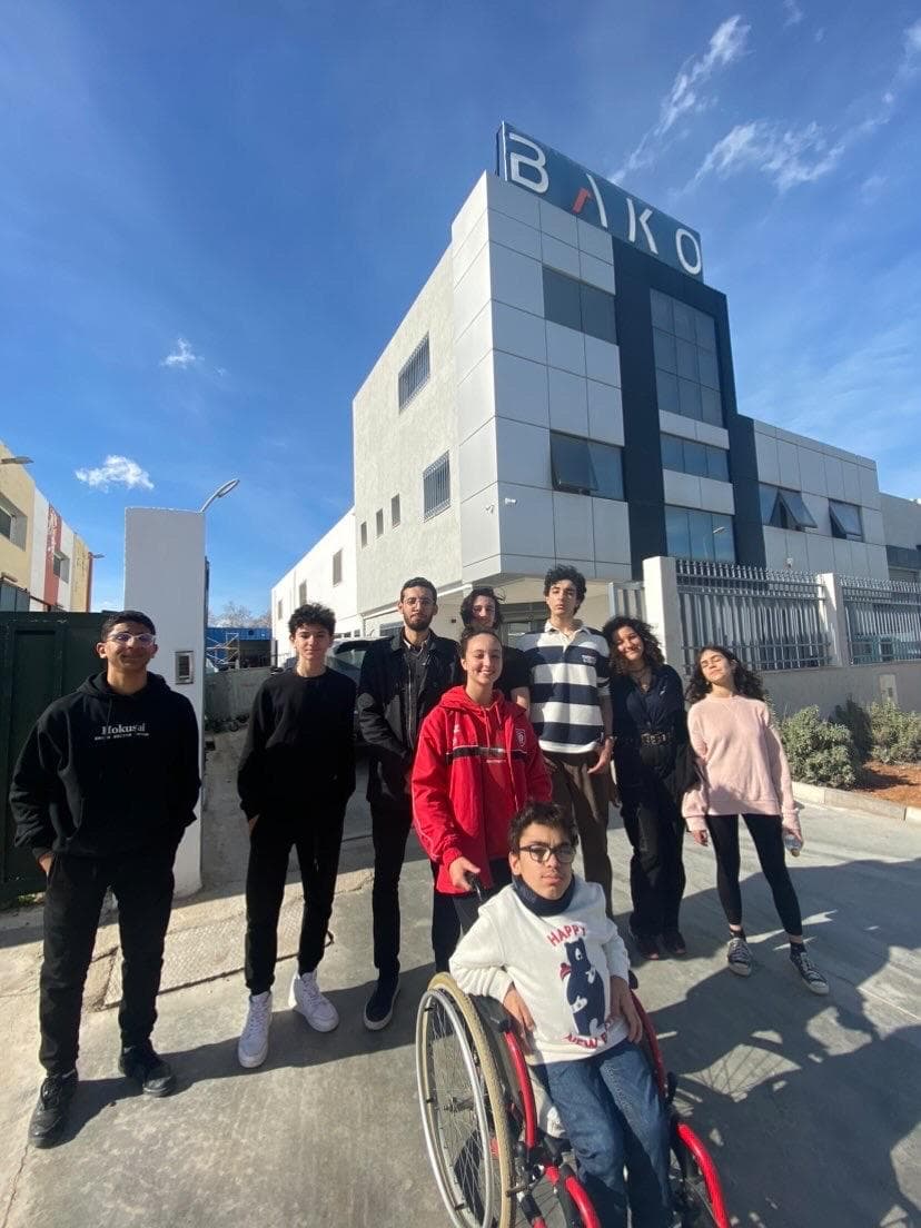 A group standing outside a white building.