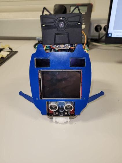 A blue electronic device with a screen and small sensors.