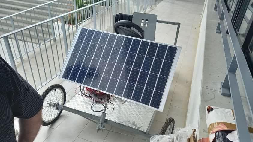 A solar panel mounted on a wheeled metal frame.