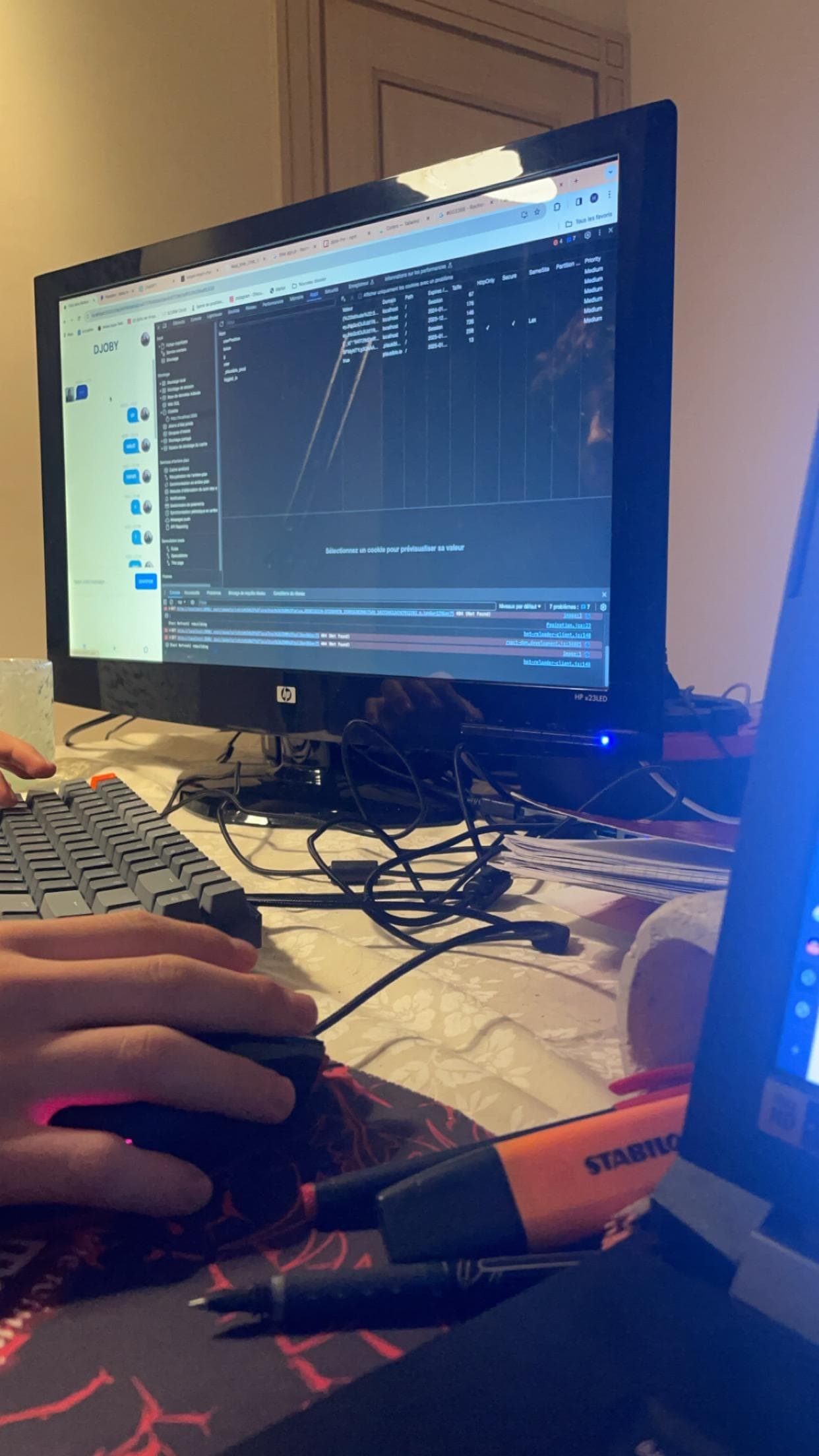 Hands on a keyboard below a screen displaying code.