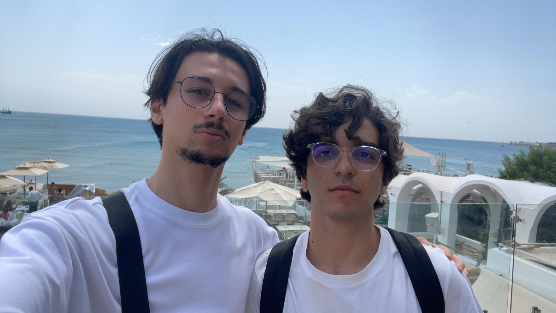 Two people outdoors with the sea in the background.