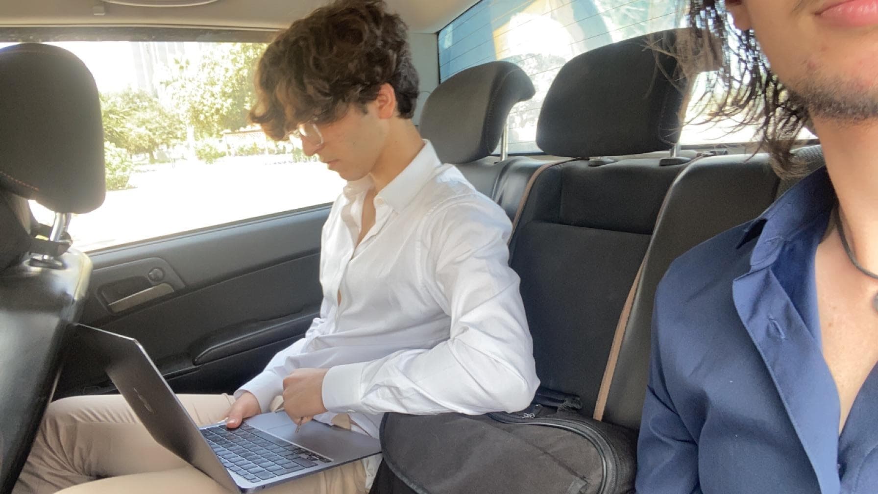 A person seated in the back of a car.