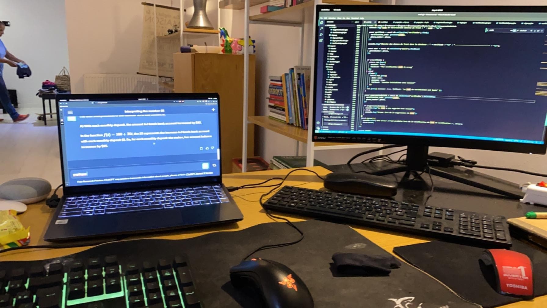 A laptop and external monitor displaying text and code.
