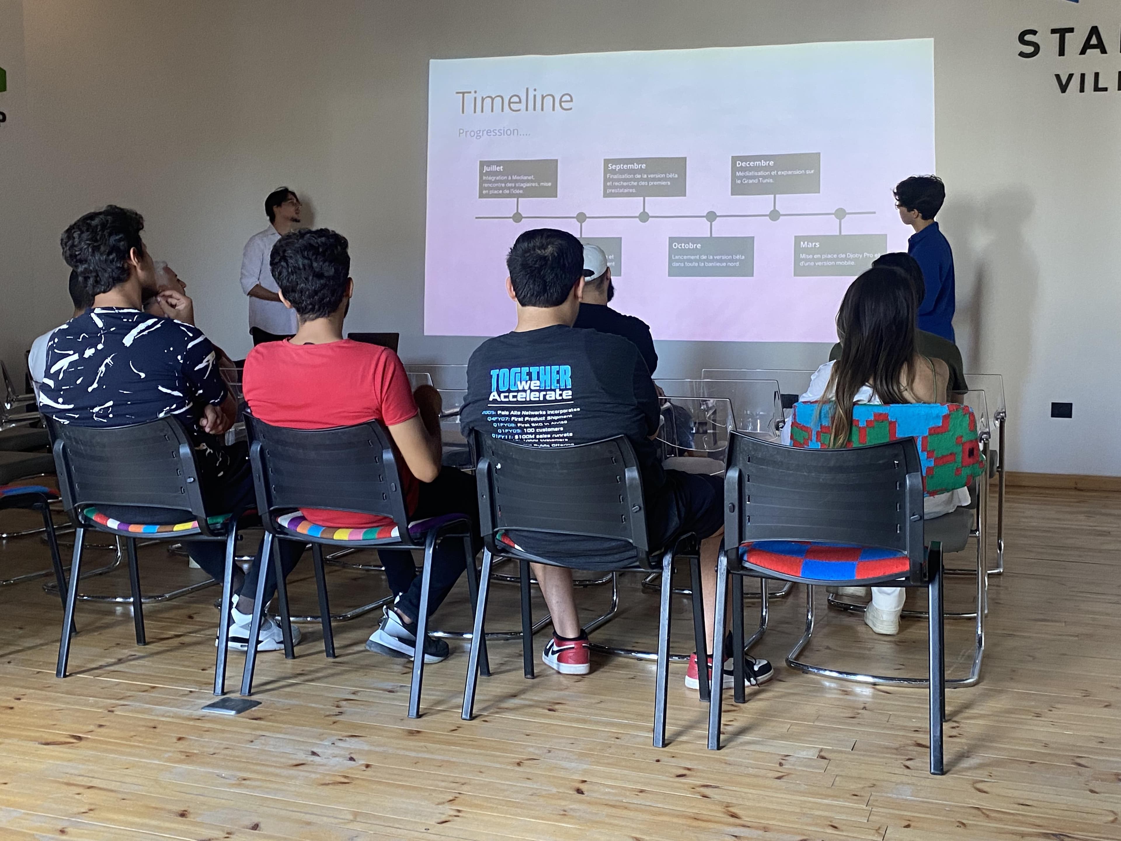 People seated in front of a projected timeline presentation.