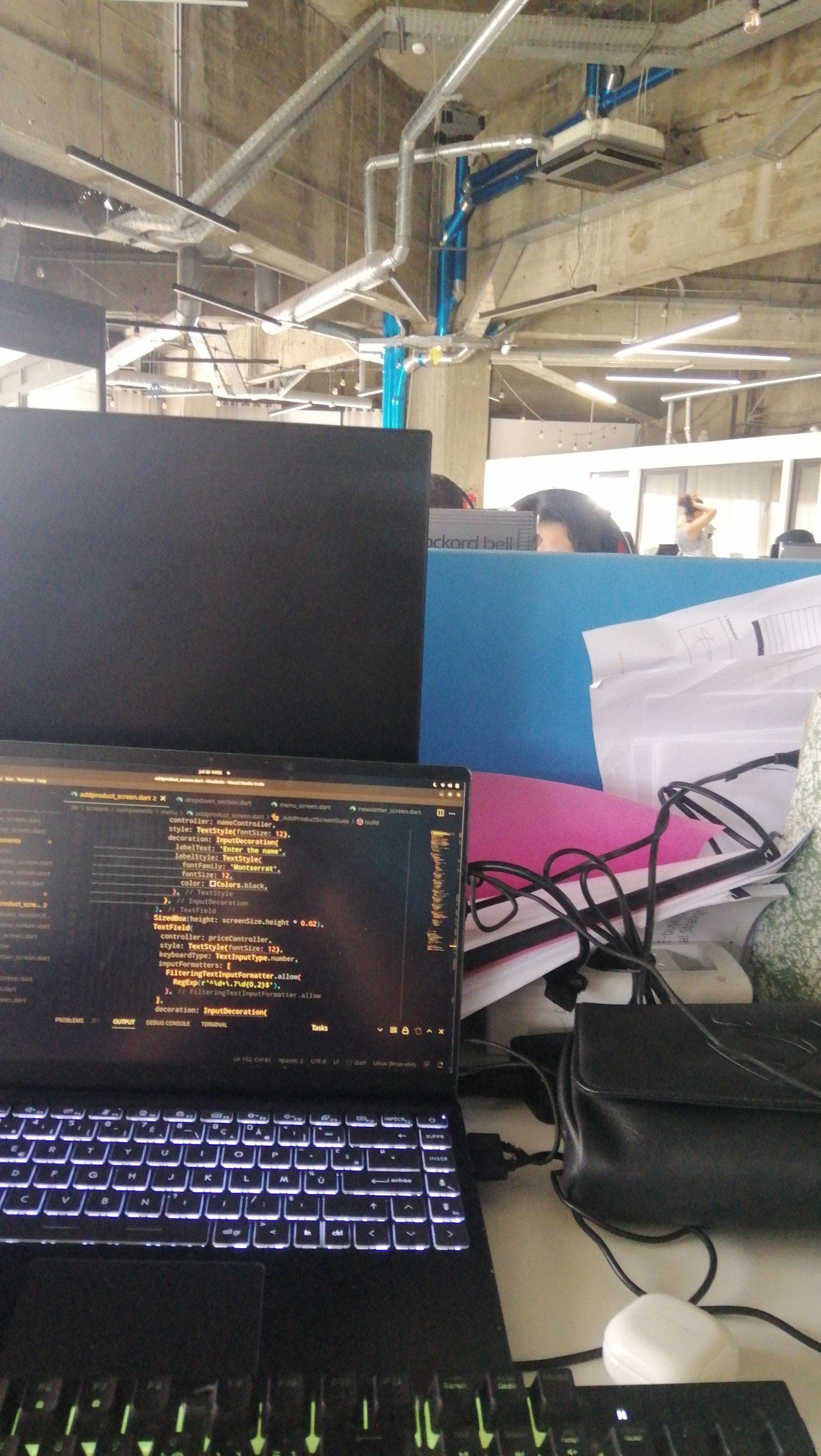 A laptop and large monitor in an open workspace.
